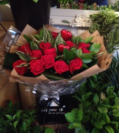 Red Rose Delight - 12 Long stem quality red roses hand tied with bespoke foliage and grass. The design is arranged ready for display in a vase or container once removed from its bespoke packaging.